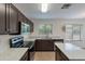 A kitchen with an island, dark cabinets, stainless steel appliances, and gray countertops at 15725 W Lundberg St, Surprise, AZ 85374