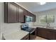 A kitchen featuring stainless steel appliances, dark cabinets, gray countertops, and tile flooring at 15725 W Lundberg St, Surprise, AZ 85374