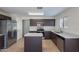 A kitchen featuring dark cabinets, stainless steel appliances, an island, and speckled gray countertops at 15725 W Lundberg St, Surprise, AZ 85374