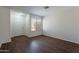 Light-filled living room features wood-look floors and neutral walls and a white front door at 15725 W Lundberg St, Surprise, AZ 85374