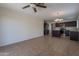 Living space features ceramic tile floors and leads into a kitchen with stainless steel appliances and dark cabinetry at 15725 W Lundberg St, Surprise, AZ 85374
