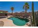 Inviting backyard pool is framed by desert landscaping, including palm trees, and a charming covered patio at 15725 W Lundberg St, Surprise, AZ 85374