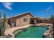 Backyard pool with stone accents, desert landscaping, and covered patio, perfect for outdoor entertaining at 15725 W Lundberg St, Surprise, AZ 85374