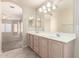 Bright bathroom featuring double sinks, spacious vanity, and neutral tile floors at 1625 E Daisy St, Casa Grande, AZ 85122