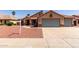 Charming single-story home featuring a three-car garage, desert landscaping, and a tile roof at 1625 E Daisy St, Casa Grande, AZ 85122