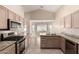 Open-concept kitchen with stainless steel appliances, tile floors and views to the dining area at 1625 E Daisy St, Casa Grande, AZ 85122