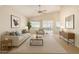 Bright living room featuring a ceiling fan, neutral walls, and sliding door access to the outdoors at 1625 E Daisy St, Casa Grande, AZ 85122