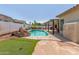 Inviting backyard oasis with a pool, covered patio, and a putting green at 16337 W Pierce St, Goodyear, AZ 85338