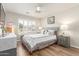 A sunlit bedroom with neutral walls, white bedding, and modern gray accent furniture at 16337 W Pierce St, Goodyear, AZ 85338