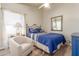 A well-lit bedroom featuring a comfortable bed, a decorative mirror, and a soft accent chair at 16337 W Pierce St, Goodyear, AZ 85338