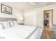A modern bedroom features white bedding, natural light, and a view to the hallway at 16337 W Pierce St, Goodyear, AZ 85338