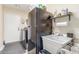 Laundry room with appliances, utility sink, shelving, and access to the backyard at 16337 W Pierce St, Goodyear, AZ 85338