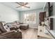 Living room features a large sectional sofa, TV, light blue walls and wood-look floors at 16337 W Pierce St, Goodyear, AZ 85338