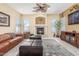 Spacious living room with a fireplace, ceiling fan, and a wall-mounted television at 16337 W Pierce St, Goodyear, AZ 85338