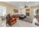 Spacious living room with a cozy fireplace, ceiling fan, and comfortable furniture at 16337 W Pierce St, Goodyear, AZ 85338