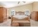 A spacious main bedroom boasts vaulted ceilings, plantation shutters, and natural wood furniture at 16337 W Pierce St, Goodyear, AZ 85338