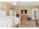 A spacious main bedroom featuring wood floors, a ceiling fan, and a door to the backyard at 16337 W Pierce St, Goodyear, AZ 85338