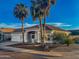 Charming single-Gathering home with well-maintained landscaping and mature palm trees against a bright blue sky at 16398 N Oachs Dr, Surprise, AZ 85374