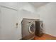 Laundry room equipped with modern washer and dryer, built-in storage cabinets, and wood-look floors at 16398 N Oachs Dr, Surprise, AZ 85374