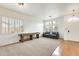 Inviting living room with bright windows, a shuffleboard game table, and comfortable seating at 16398 N Oachs Dr, Surprise, AZ 85374