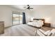 Bright main bedroom with a ceiling fan, plush carpet, ensuite bathroom and sliding doors to the pool area at 16398 N Oachs Dr, Surprise, AZ 85374