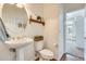 Charming powder room featuring a pedestal sink, wood-look floors and decorative accents at 16398 N Oachs Dr, Surprise, AZ 85374