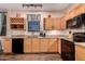 Bright kitchen features wood cabinets, granite countertops, black appliances, and hardwood floors at 1721 E Cielo Grande Ave, Phoenix, AZ 85024