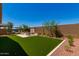 Spacious backyard featuring artificial grass, a modern fireplace, and comfortable lounge seating at 17650 W Bajada Rd, Surprise, AZ 85387