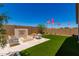Expansive backyard showcasing a modern outdoor fireplace, artificial turf, and desert landscaping at 17650 W Bajada Rd, Surprise, AZ 85387
