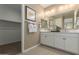 Bright bathroom with dual sinks, white cabinetry, and a large mirror reflecting natural light at 17650 W Bajada Rd, Surprise, AZ 85387