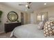 Cozy bedroom with a round mirror over a dresser, soft lighting, and a comfortable king-size bed at 17650 W Bajada Rd, Surprise, AZ 85387
