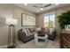 A stylish living room with a gray sectional sofa, modern art, and bright natural light at 17650 W Bajada Rd, Surprise, AZ 85387