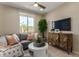 A cozy living room featuring a gray sofa, round coffee table, and stylish entertainment center at 17650 W Bajada Rd, Surprise, AZ 85387