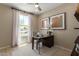 A modern home office setup with a sleek desk, neutral rug, and natural light from the window at 17650 W Bajada Rd, Surprise, AZ 85387