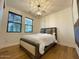 Bedroom features hardwood floors, natural light, a decorative ceiling light, and neutral wall colors at 18507 N 94Th St, Scottsdale, AZ 85255
