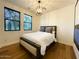 Cozy bedroom featuring a full bed, modern light fixture, and wood flooring at 18507 N 94Th St, Scottsdale, AZ 85255