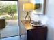 Entryway with a view to the front yard, hardwood floors, side cabinet, lamp, and artwork at 18507 N 94Th St, Scottsdale, AZ 85255