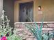 Charming front door of home with decorative sidelight, stone accents, and manicured landscaping at 18507 N 94Th St, Scottsdale, AZ 85255