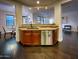 Modern kitchen with wooden cabinets, stainless steel dishwasher and breakfast bar with natural stone countertop at 18507 N 94Th St, Scottsdale, AZ 85255