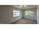 Cozy bedroom with neutral carpet, modern light fixture, and sun-filled windows at 1916 W Morningside Dr # 111, Phoenix, AZ 85023