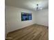 Bedroom features wood floors, a modern light fixture, and a large window at 1916 W Morningside Dr # 111, Phoenix, AZ 85023