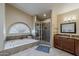 Bathroom with large tub, tiled shower with glass door, and large window at 1927 E Ranch Rd, Tempe, AZ 85284