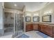 Bright bathroom featuring tiled shower with glass door and dual vanity at 1927 E Ranch Rd, Tempe, AZ 85284