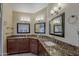 Bathroom featuring dual sinks with granite countertops and warm brown cabinetry at 1927 E Ranch Rd, Tempe, AZ 85284