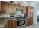 Kitchen with granite counters, stainless steel appliances, decorative backsplash, and wooden cabinets at 1927 E Ranch Rd, Tempe, AZ 85284