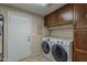 Well-lit laundry room with cabinets, modern washer, and dryer at 1927 E Ranch Rd, Tempe, AZ 85284
