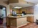 View of kitchen featuring wood cabinets, tile countertops, breakfast bar, and stainless steel refrigerator at 19814 N 49Th Dr, Glendale, AZ 85308