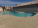 Community pool view with clear blue water, surrounded by concrete patio and residential buildings at 19814 N 49Th Dr, Glendale, AZ 85308