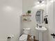 Cozy powder room with decorative shelves, neutral paint, pedestal sink and oval mirror at 19905 E Apricot Ln, Queen Creek, AZ 85142