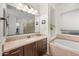Modern bathroom featuring granite counters, soaking tub, and separate glass enclosed shower at 19905 E Apricot Ln, Queen Creek, AZ 85142